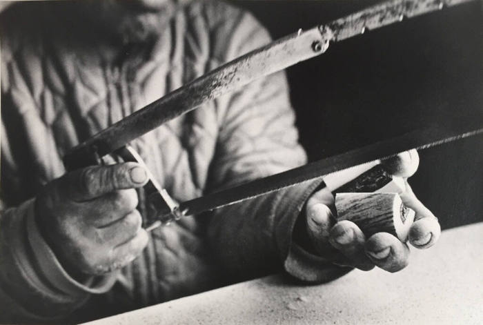 Untitled (Man Splitting Antler Horn with Saw)